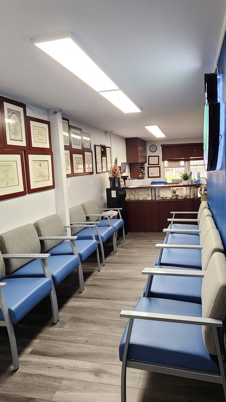 Wall of framed clinical credentials in the Flushing clinic waiting room